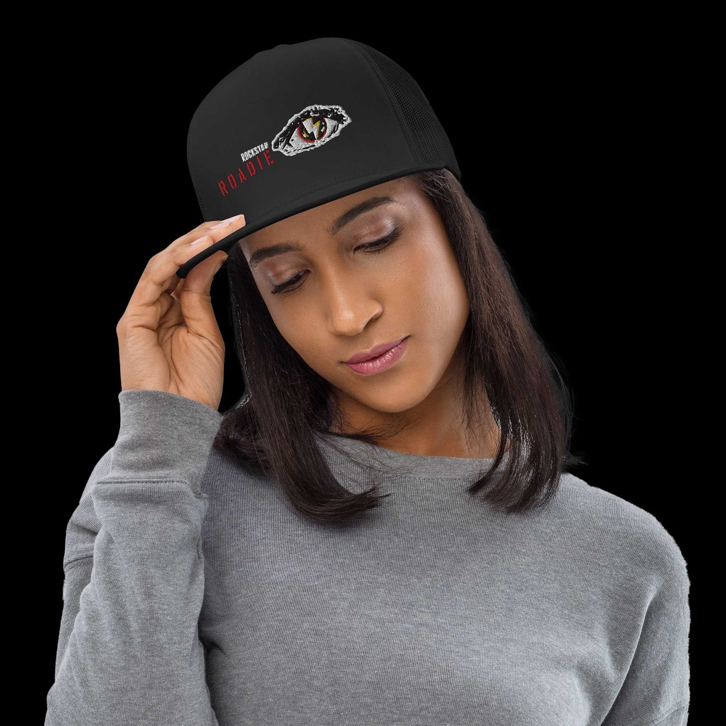 Woman wearing all-black Roadie Trucker Cap with bold rock-themed graphic, ideal for adding edgy flair to casual streetwear looks.