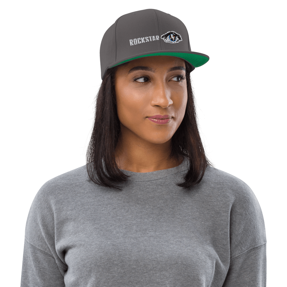 Model in gray Rockstar Snapback Hat with bold logo, ideal for streetwear lovers seeking a unique and stylish cap.